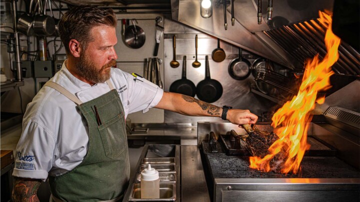 Chef Evan Robertson cooking over a grill at the Hillside Bistro