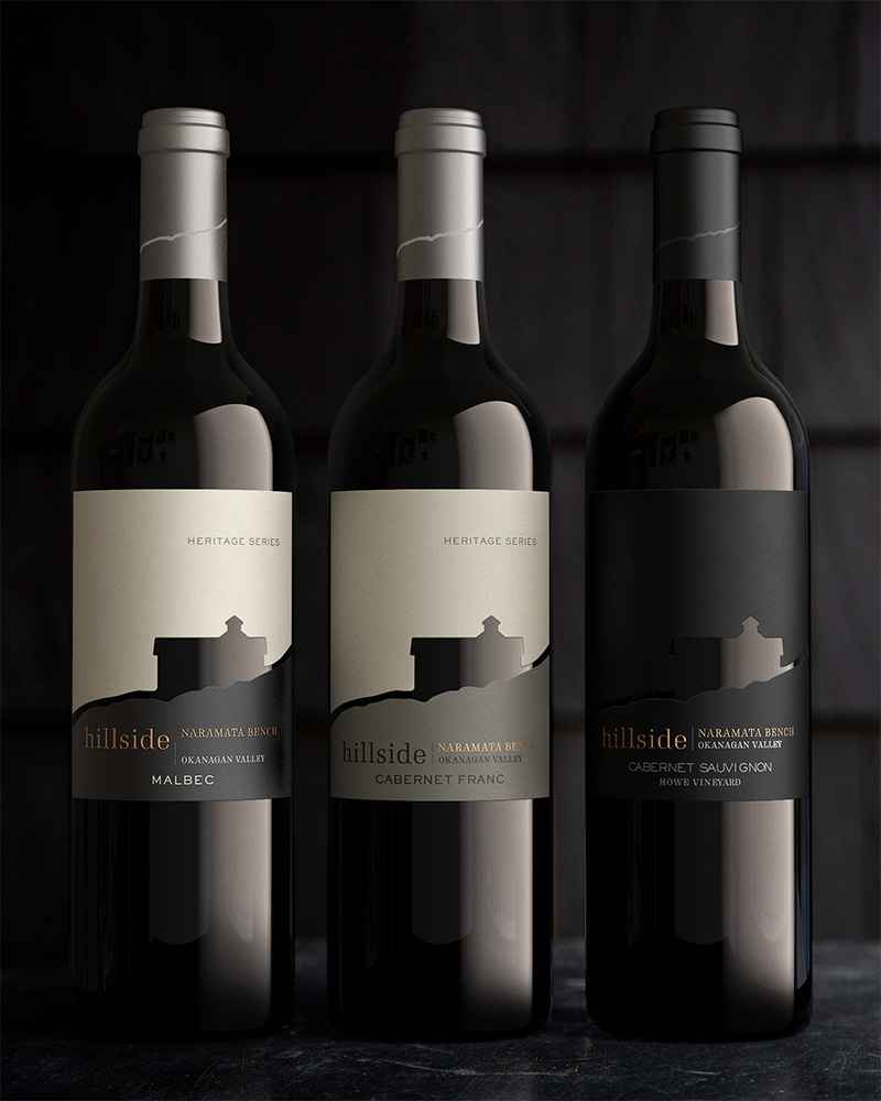 Three Hillside Winery wine bottles lined up in front of a black backdrop. The left bottle being a Malbec, the centred bottle a Cabernet Franc, the right bottle being a Cabernet Saviognon.