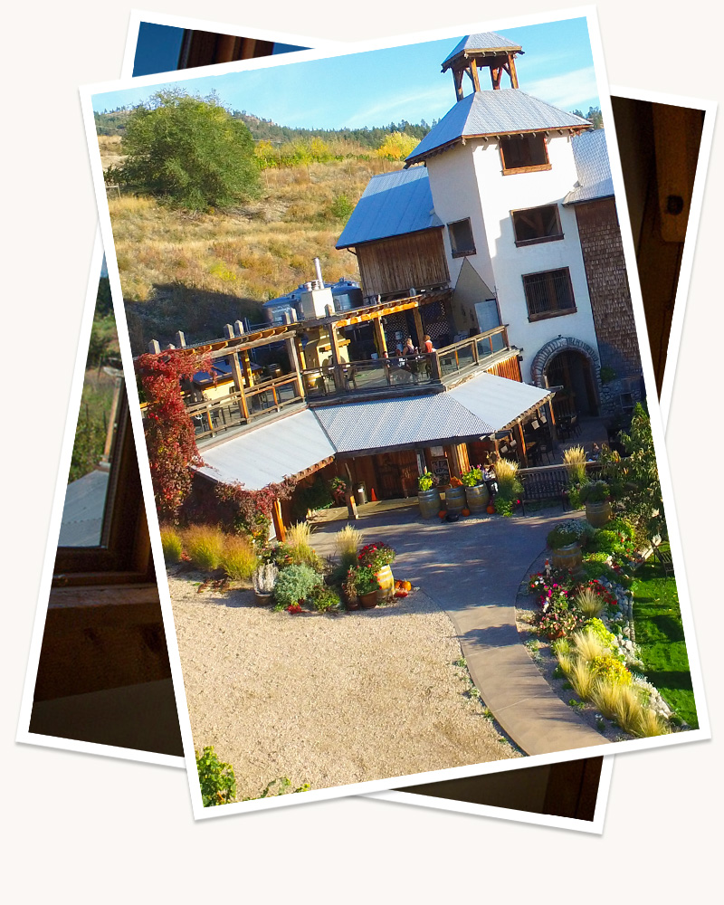 Two digitally stacked images, the top, visible image showing the Hillside Winery and Bistro on a clear, sunny day - with flourishing flowers and bushes lining the outside, a rooftop patio bathed in sunlight and the tall brick architecture of the building. 